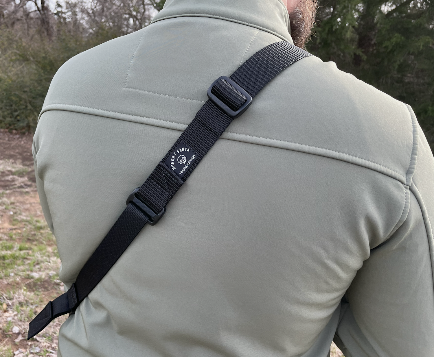 Sling from back displaying 1.25 inch webbing and quick adjust feature resized Black rifle sling worn over shoulder